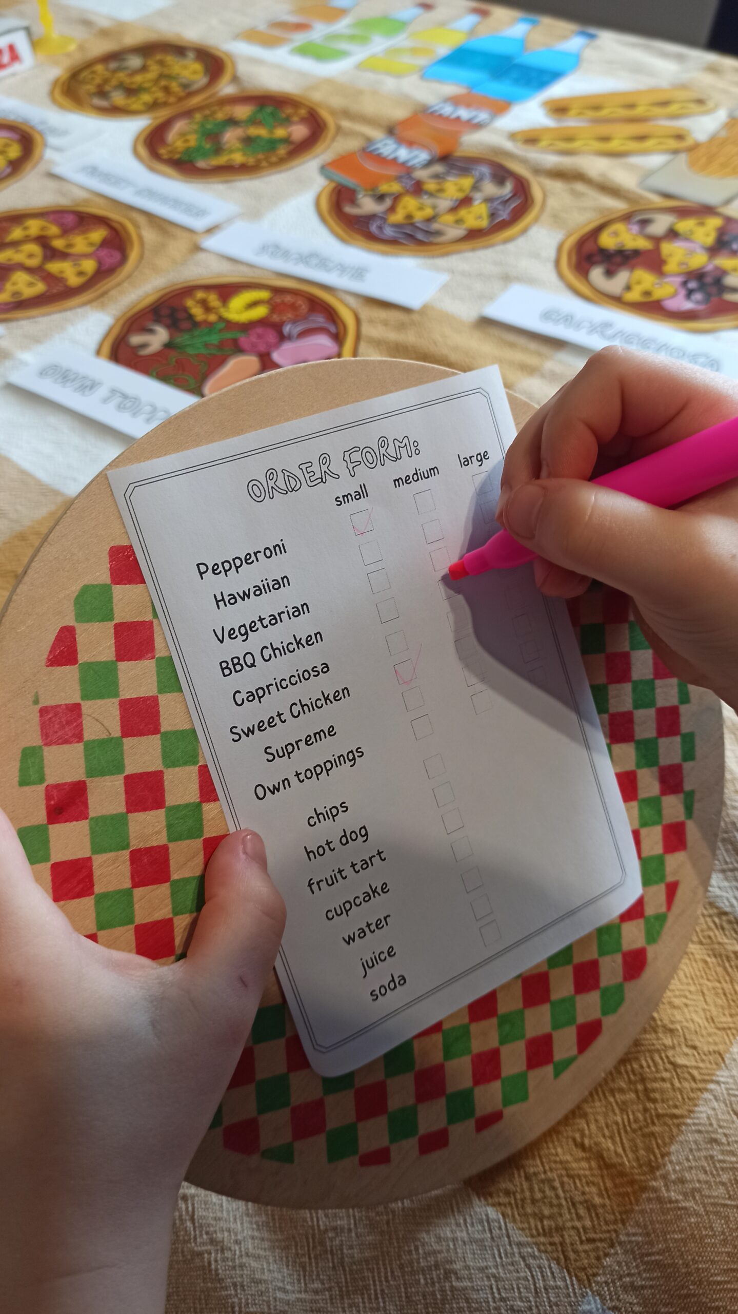 dziecko zaangażowane w zabawę w pizzerię przyjmujące zamówienie po angielsku